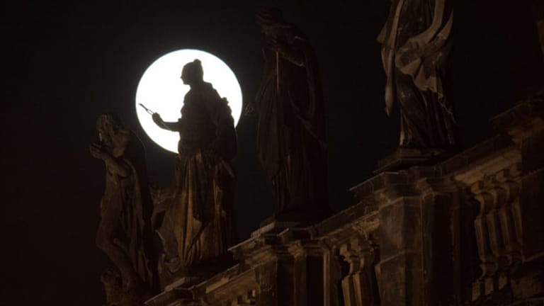 Der Mond geht am 14.11.2016 in Dresden (Sachsen) hinter den Heiligenfiguren auf der Katholischen Hofkirche auf.