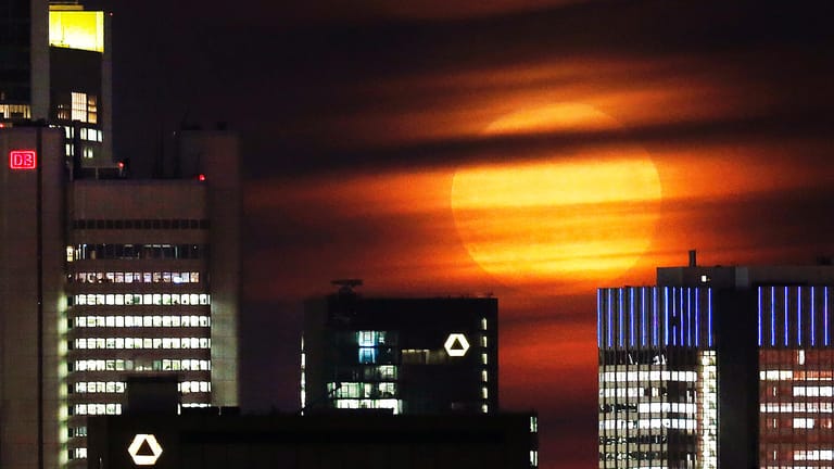 Wolkenschleier bedecken den Supermond über der Frankfurter Skyline.