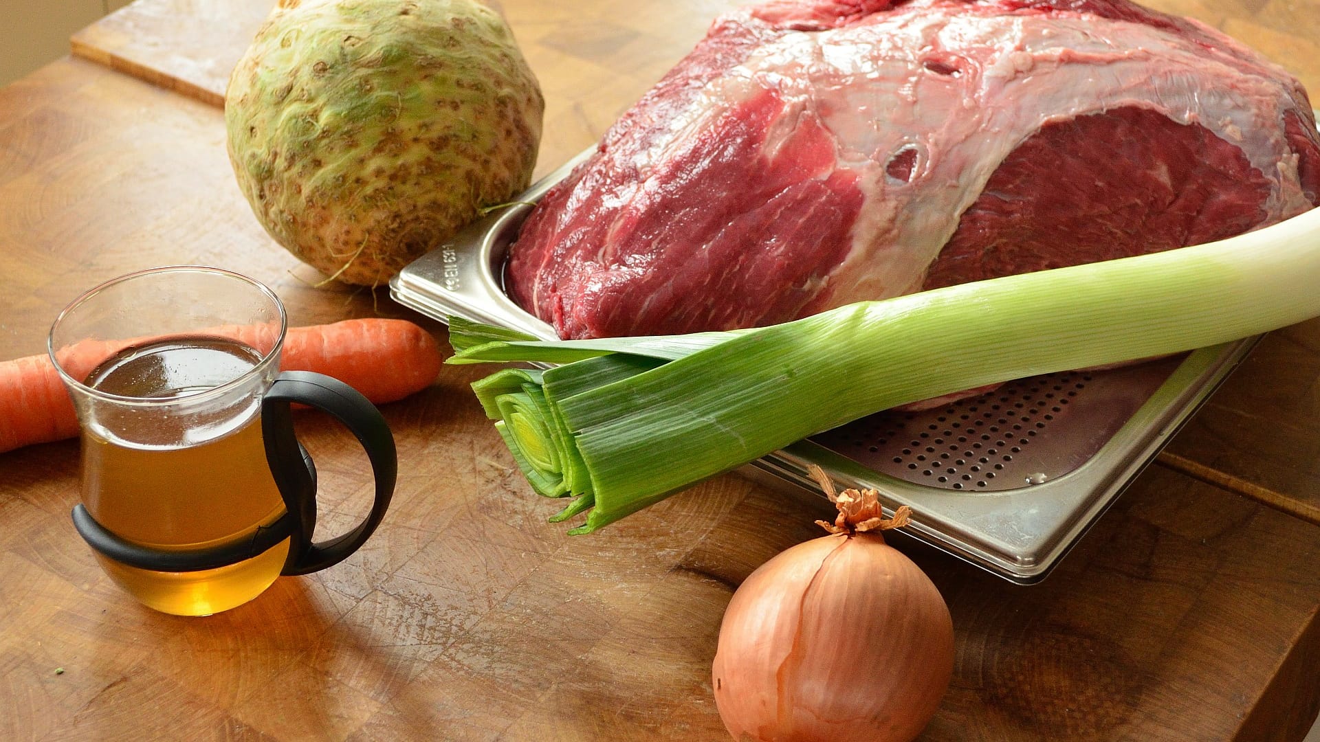 Daraus entsteht im Topf eine wärmende, aromatische Fleischbrühe: Suppenfleisch, Karotte, Sellerie, Lauch und eine halbierte Zwiebel, deren Schnitflächen ohne Fett in eine beschichteten Pfanne geröstet werden.