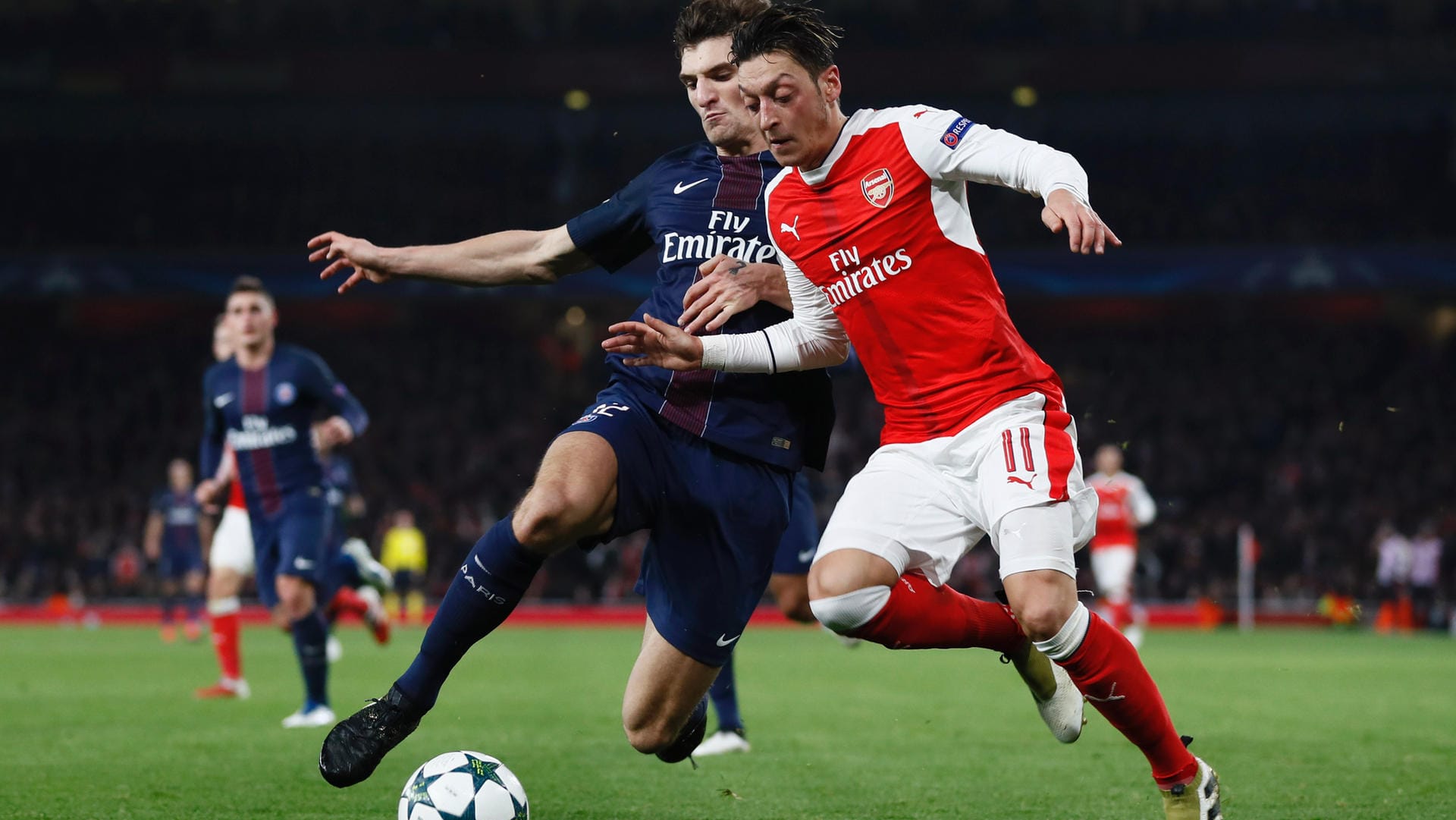 PSG-Profi Thomas Meunier (li.) versucht Arsenals Mesut Özil vom Ball zu trennen.