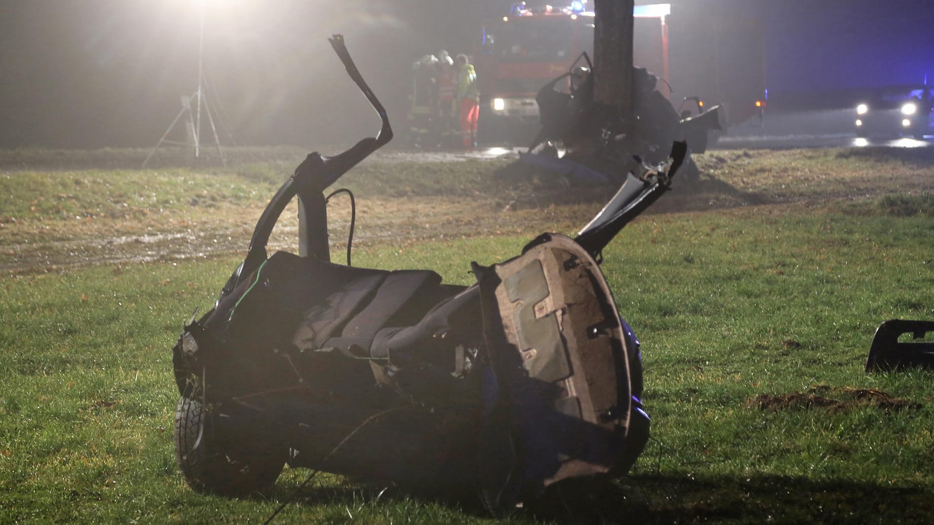 Ein Teil eines zerstörten Autos liegt auf einer Wiese neben einer Straße bei Markt Rettenbach im Unterallgäu.