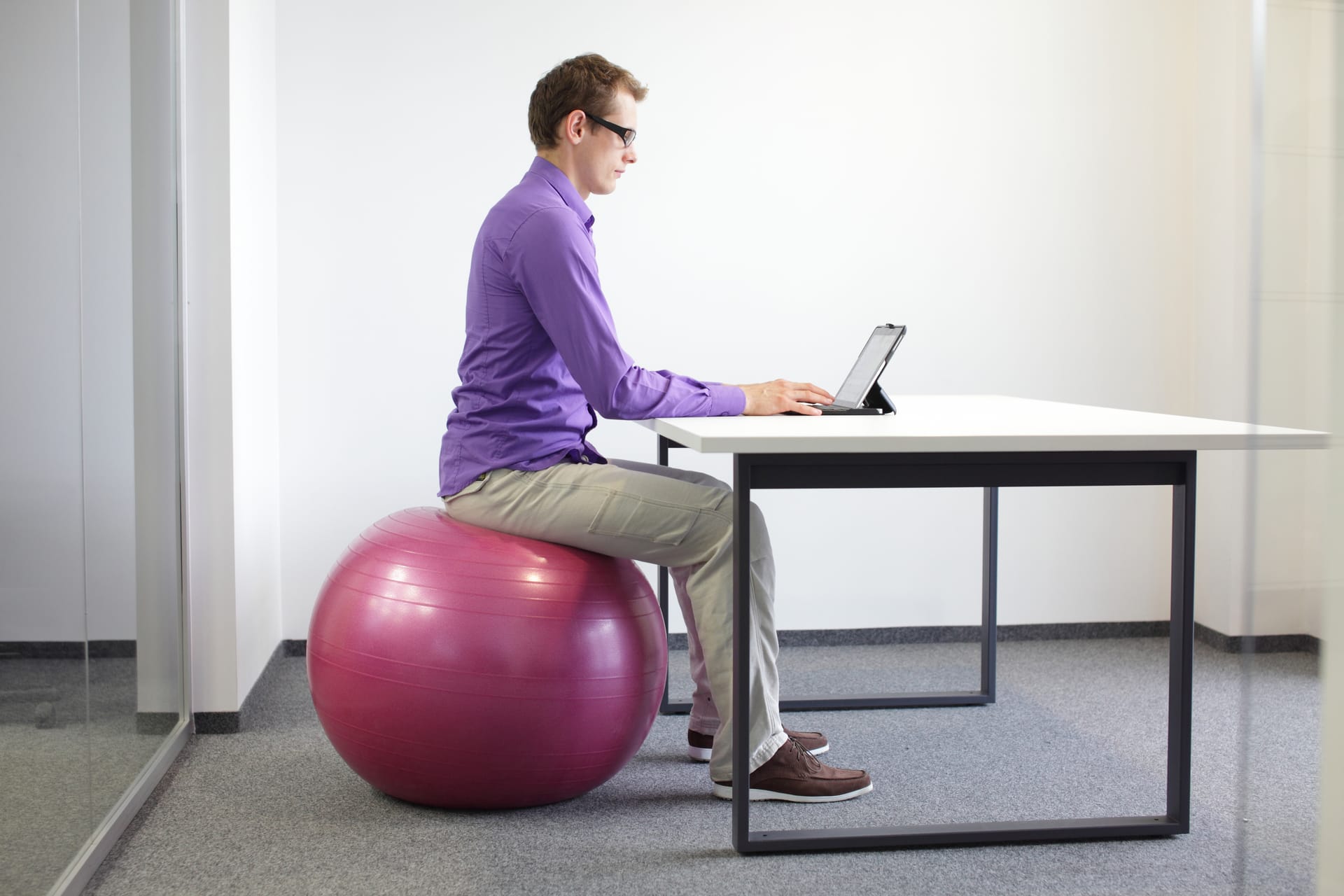 Auf einem Gymnastikball sitzend, trainieren Sie automatisch die untere Rückenmuskulatur.