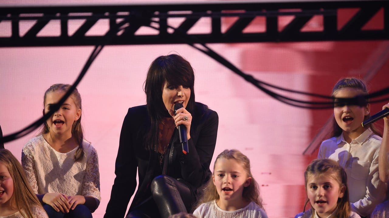 Sängerin Nena inmitten von singenden Kindern bei der Spendengala.