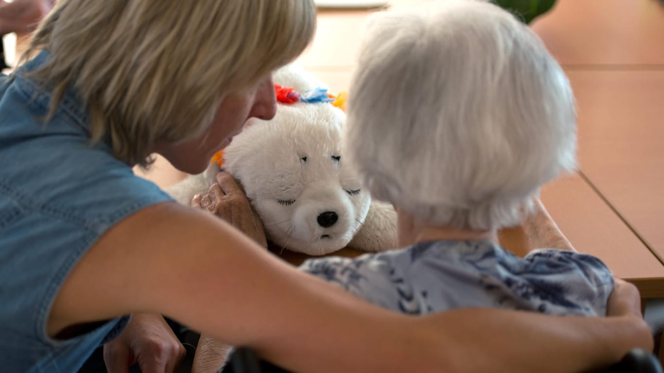 Ältere Frau spielt mit Plüscheisbär: Mit der Pflegereform sollen die Pflegeleistungen für Demenzkranke verbessert werden.
