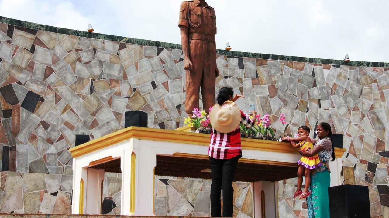 Eine Familie gedenkt vor einem Monument in Kilinochchi einem singhalesischen Kriegshelden.