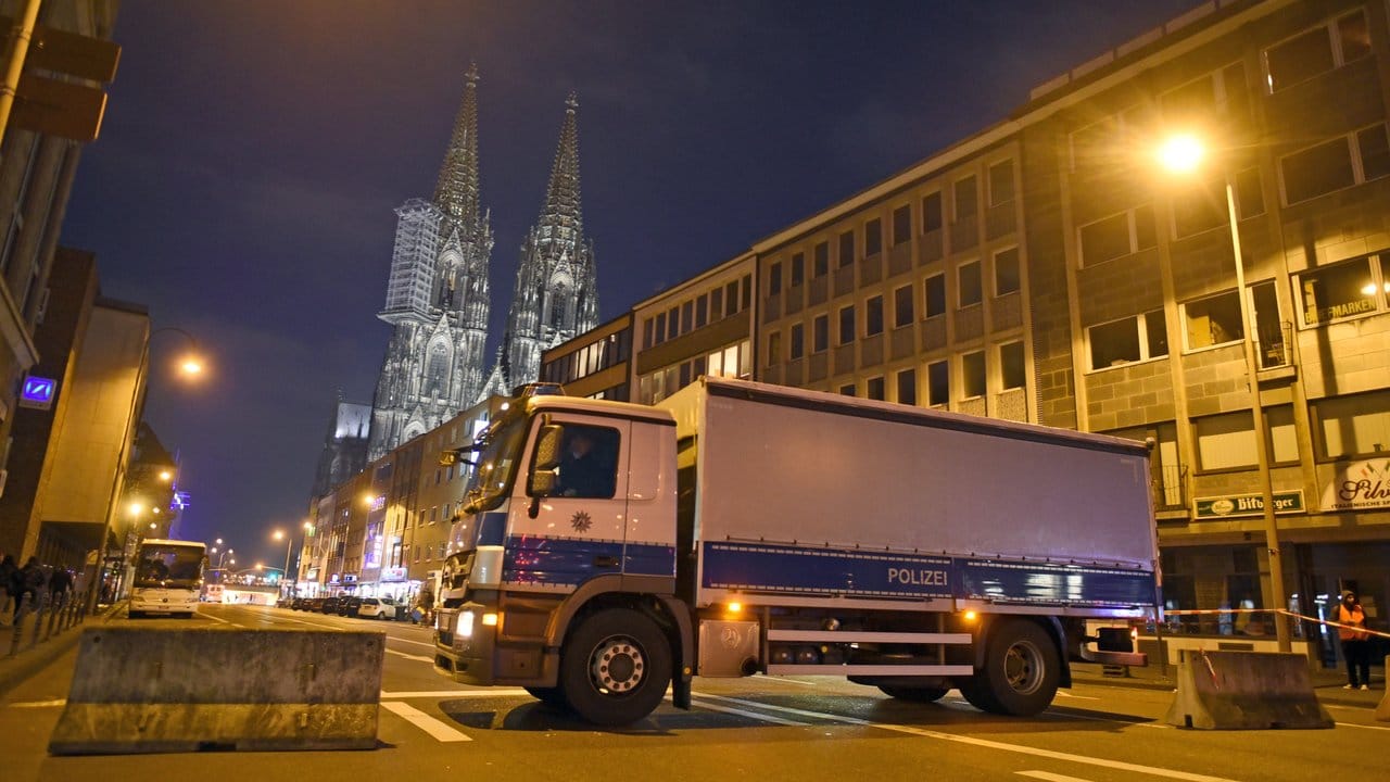 Betonsperren und ein Lastwagen der Polizei versperren eine Straße Richtung Dom.