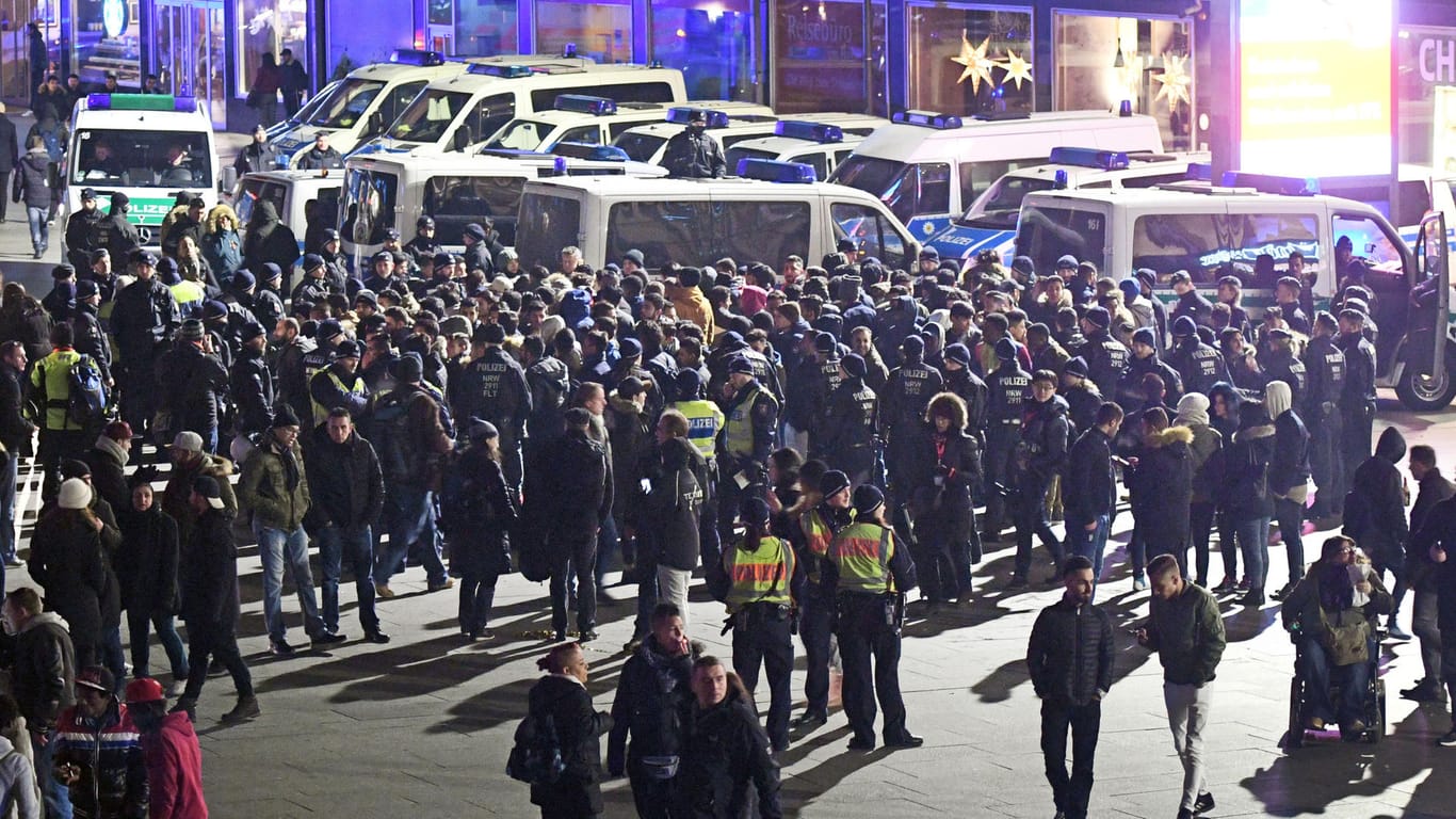 Polizisten umringen in der Silvesternacht vor dem Hauptbahnhof in Köln eine Gruppe südländisch aussehender Männer.