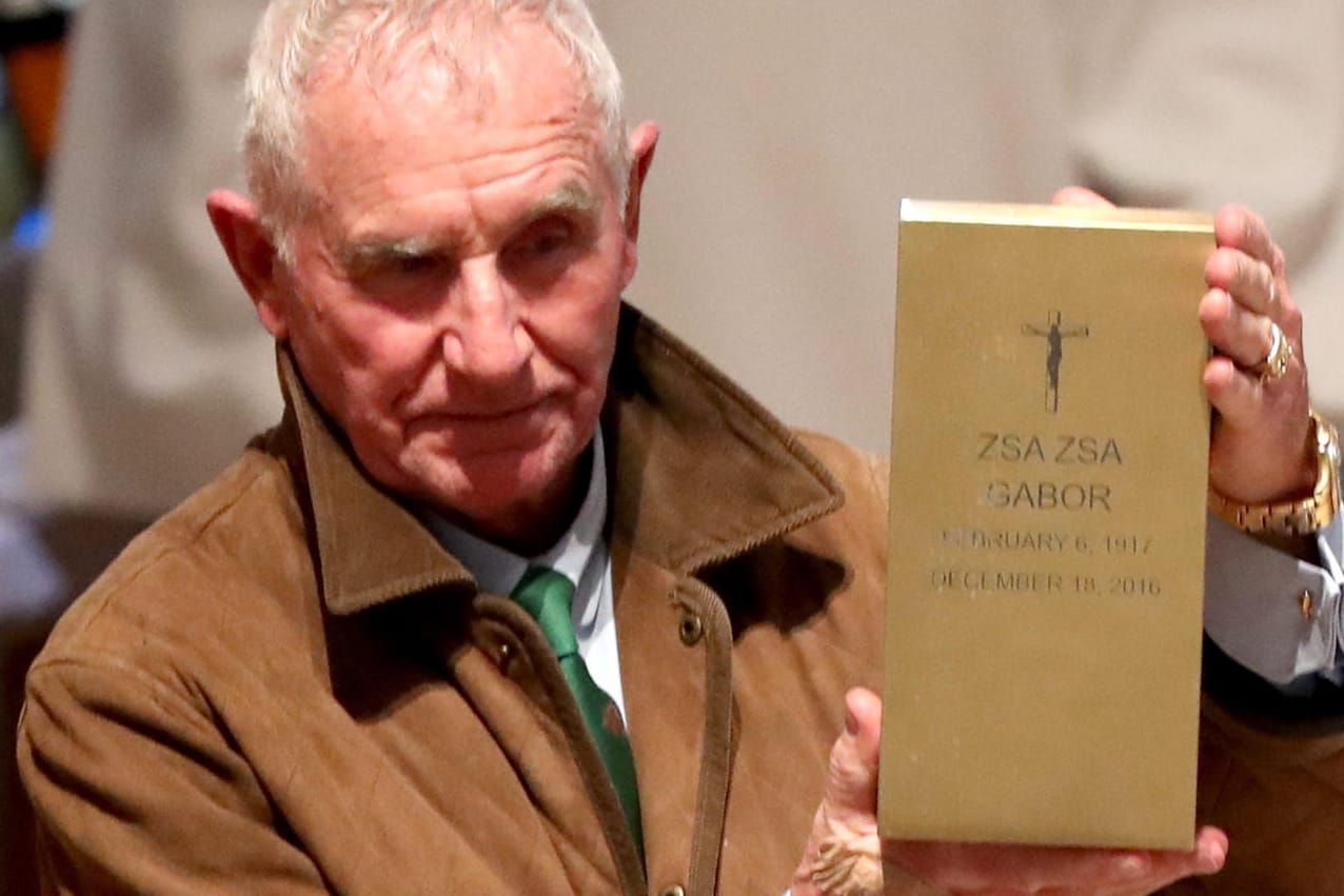 Witwer Frédéric Prinz von Anhalt zeigt nach der Trauerfeier für Zsa Zsa Gabor die vergoldete Urne seiner Frau.