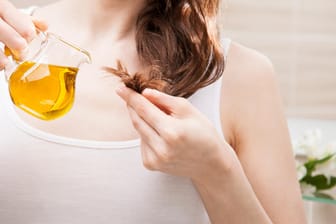 Eine Frau pflegt ihre Haarspitzen mit Öl