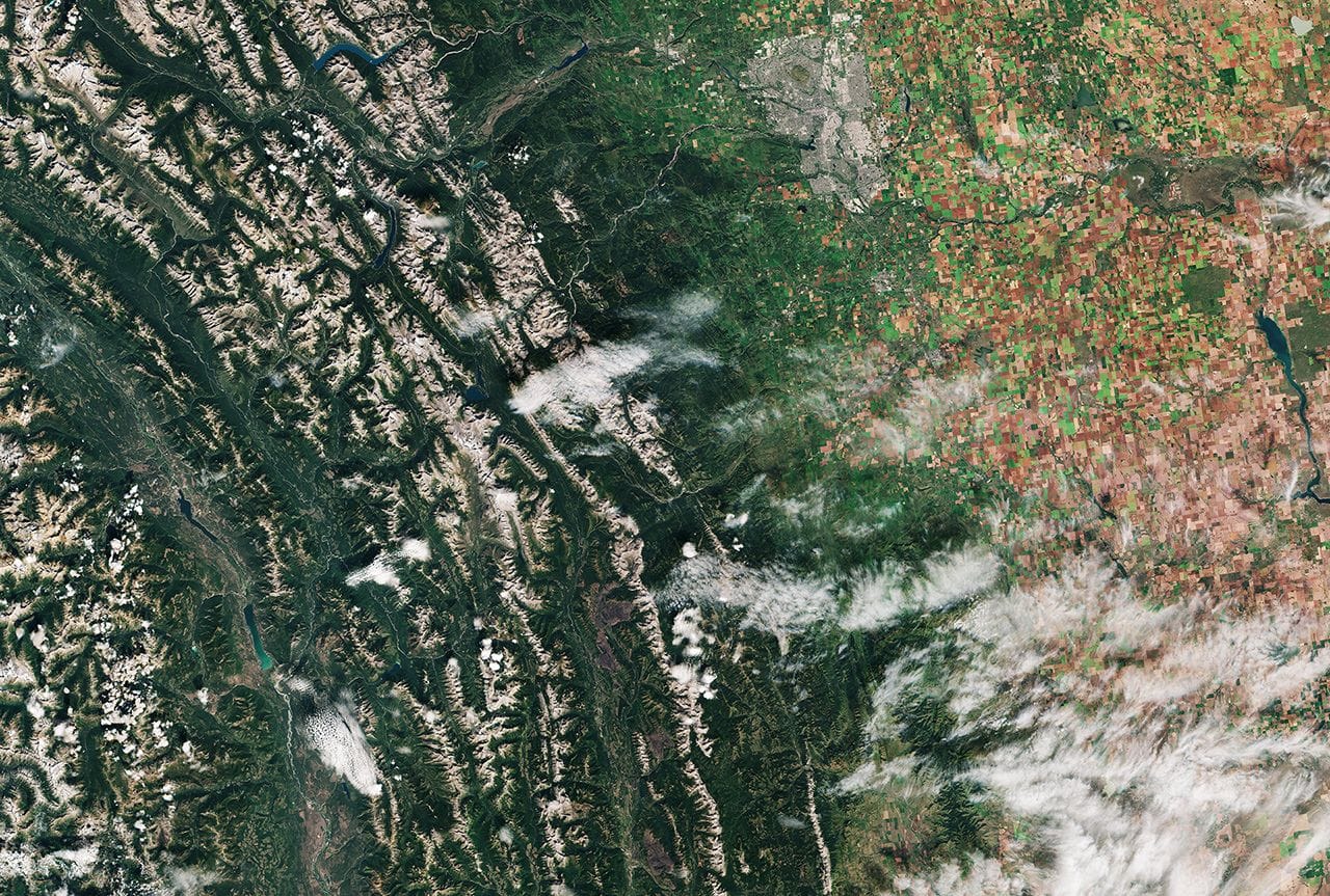 Das Satellitenbild zeigt den südlichen Teil der kanadischen Provinz Alberta. Links im Bild erkennt man die Rocky Mountains, die nach rechts in die kanadische Prärie auslaufen. Genau in dieser Zone sieht man zentral im oberen Bereich die Stadt Calgary, Gastgeber der Winterspiele von 1988.