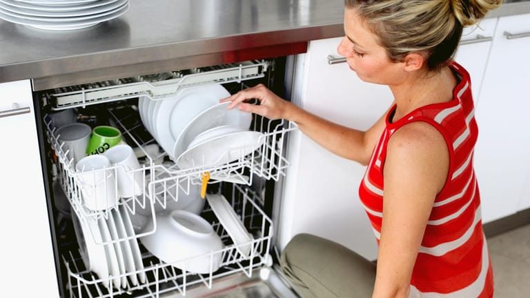 Eine Frau räumt die Spülmaschine aus