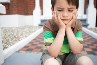 Ein Junge schaut unzufrieden: Kinder entwickeln Strategien, um mit Enttäuschungen umzugehen.