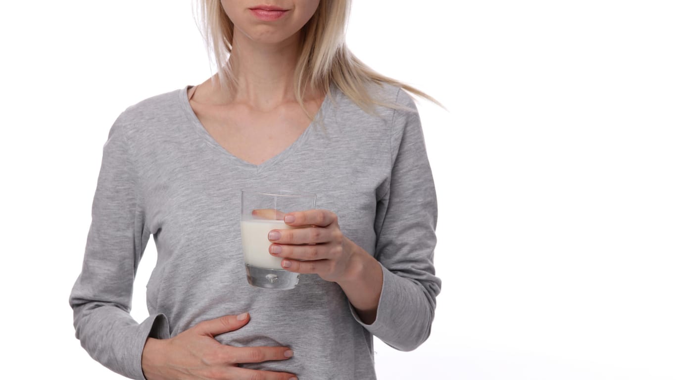 Eine Frau hält ein Glas Milch in der Hand.