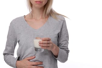 Eine Frau hält ein Glas Milch in der Hand.