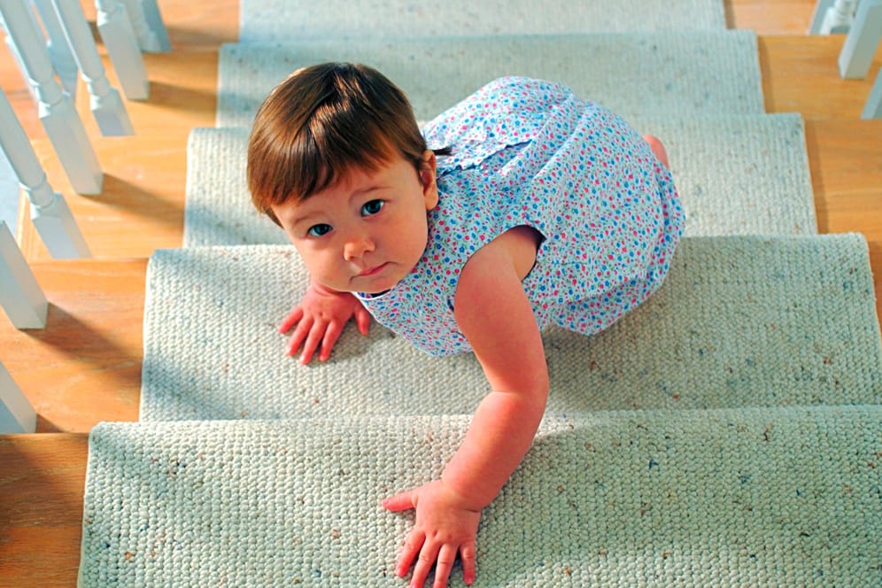 Ein Kleinkind klettern Treppenstufen hinauf.