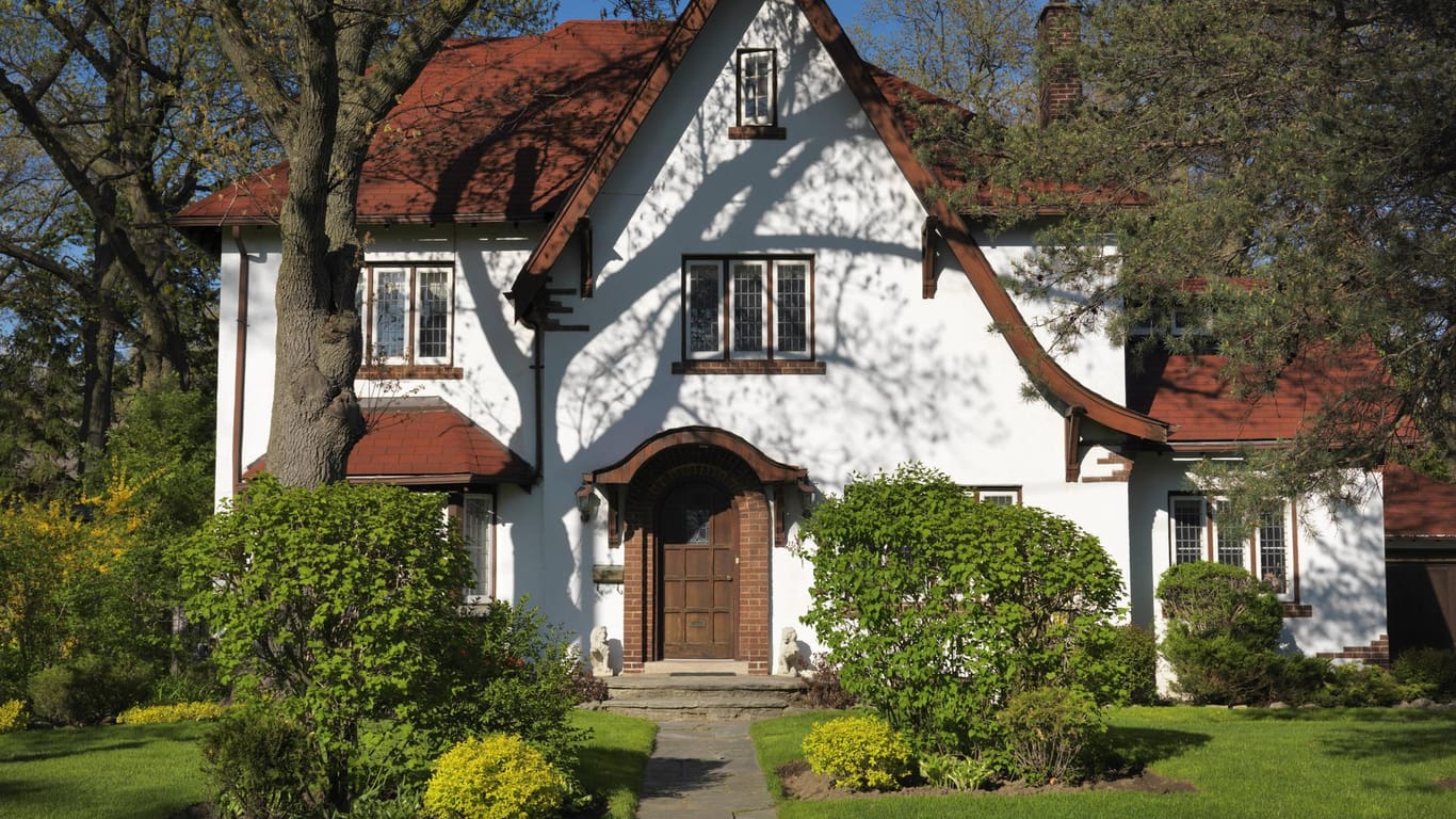 Haus mit Garten bei Sonne: Aktuell sinken die Immobilienpreise in und um die Metropolen.