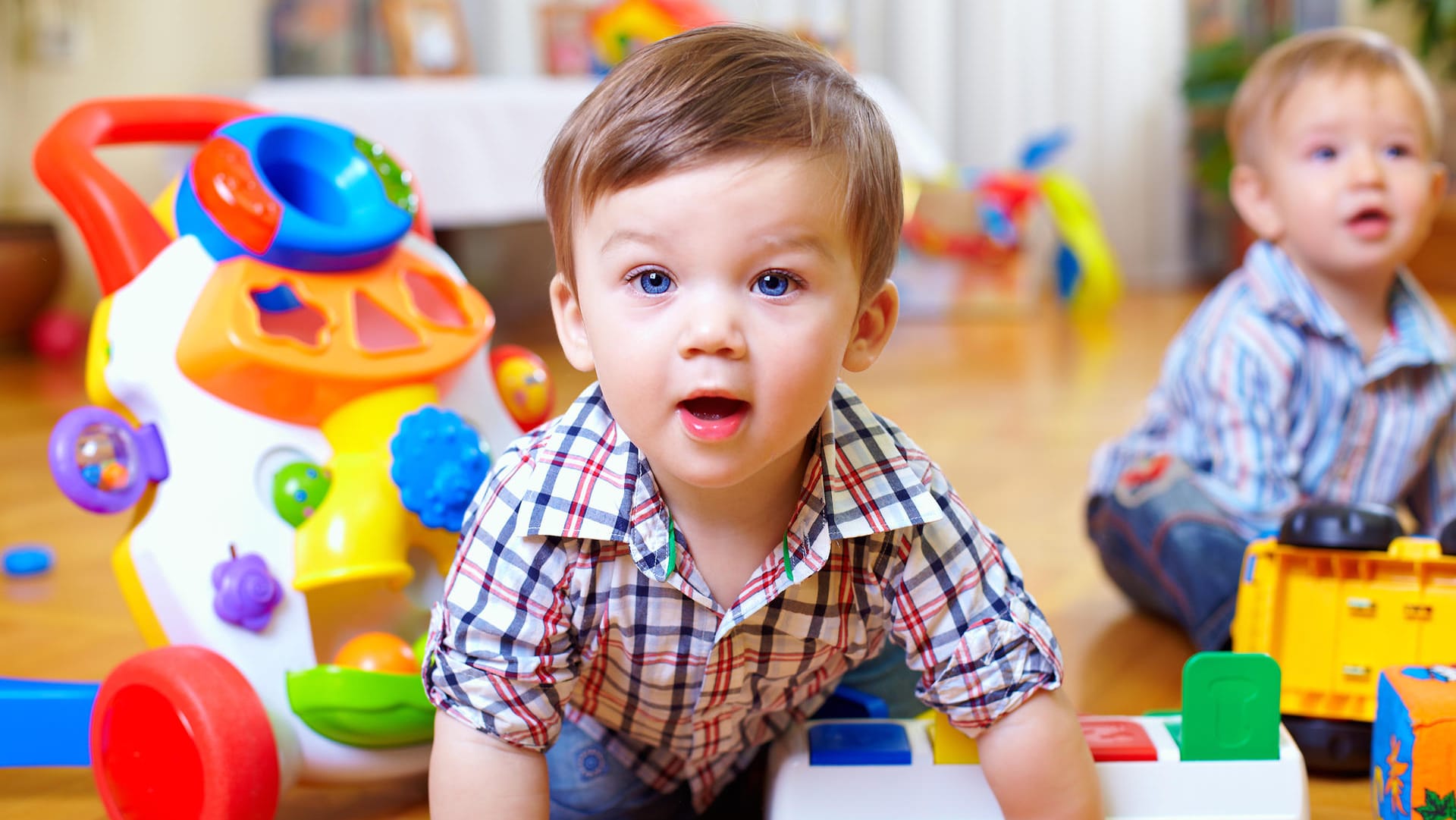 Zwei kleine Jungen sitzen in einem Kinderzimmer.