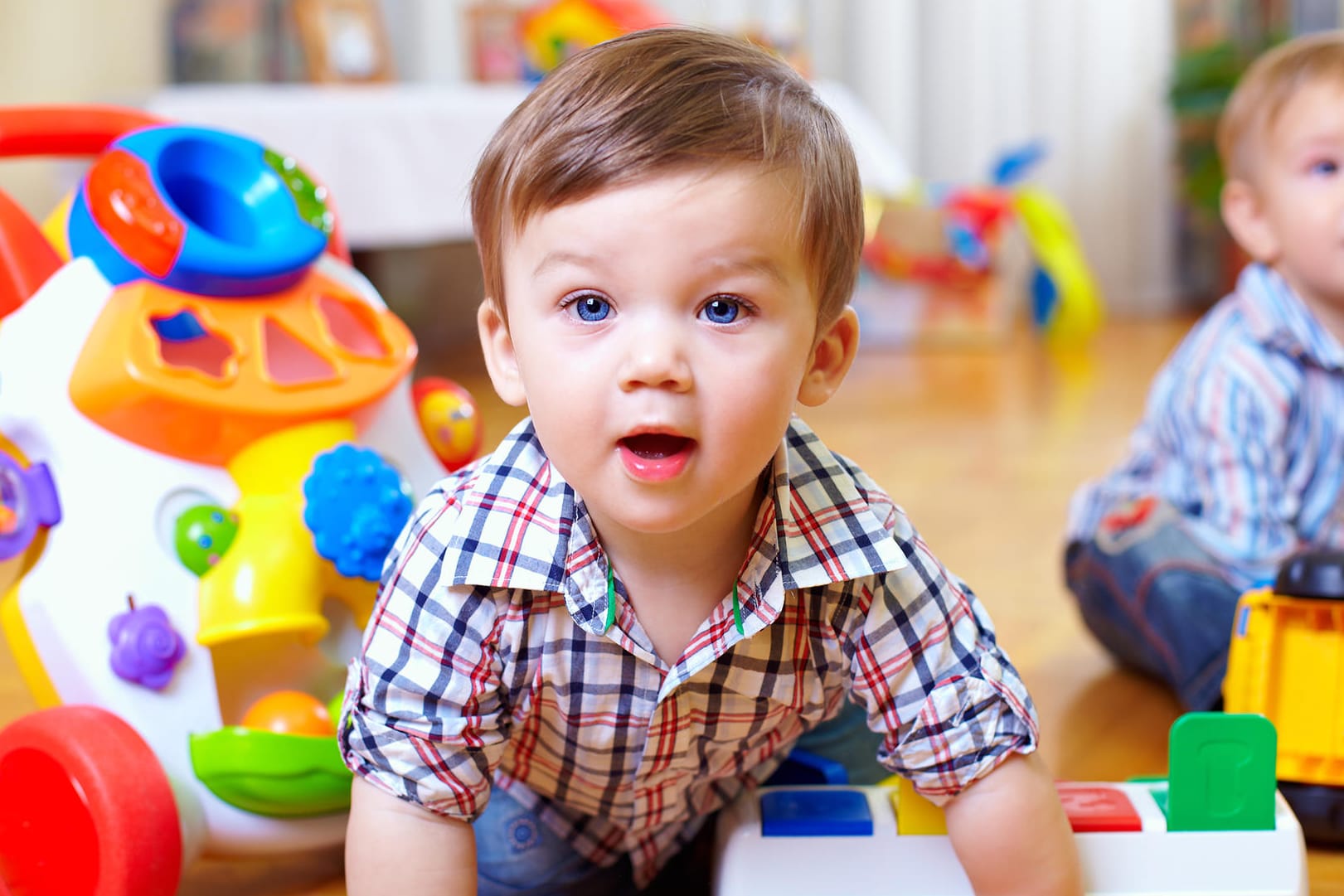 Zwei kleine Jungen sitzen in einem Kinderzimmer.