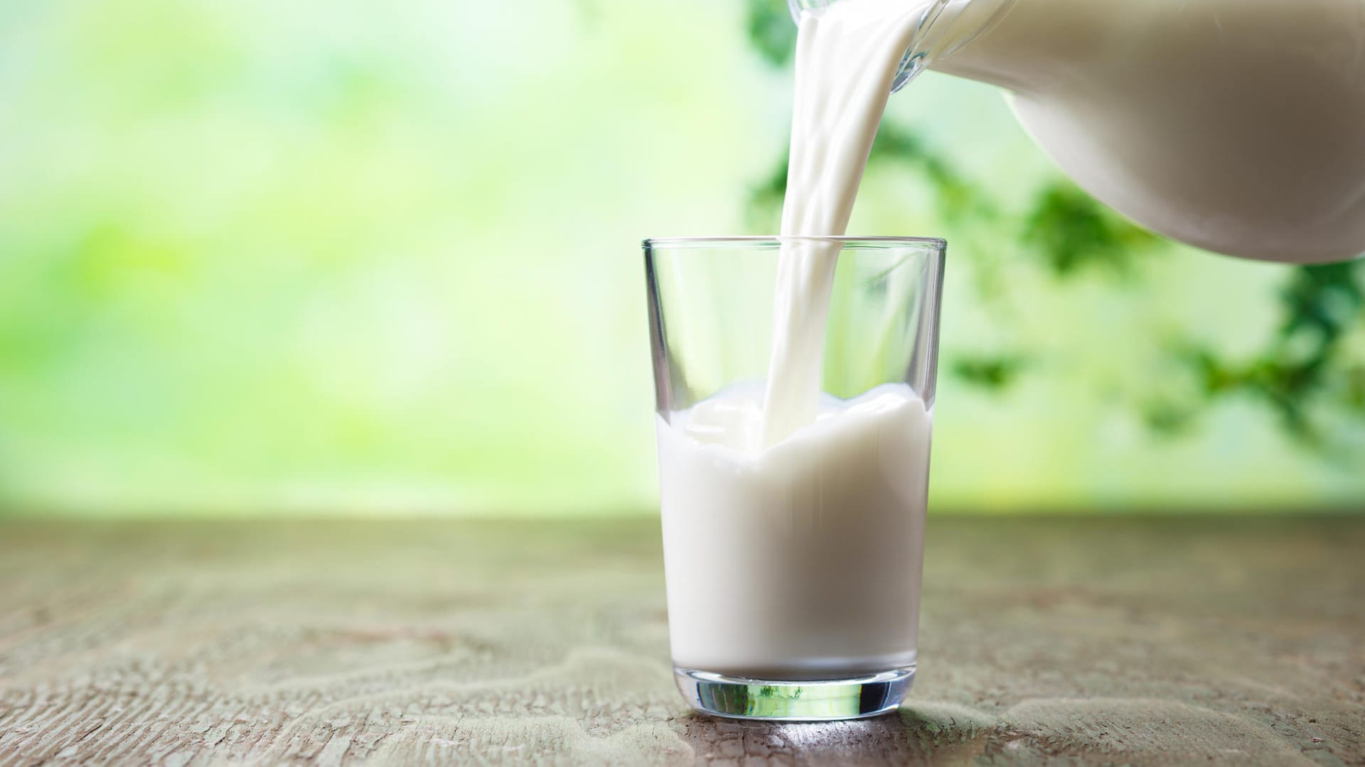 Milch wird in ein Glas eingeschenkt.