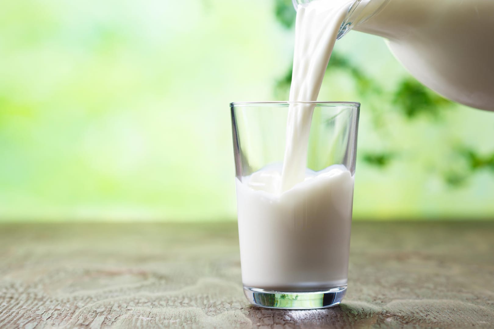 Milch wird in ein Glas eingeschenkt.