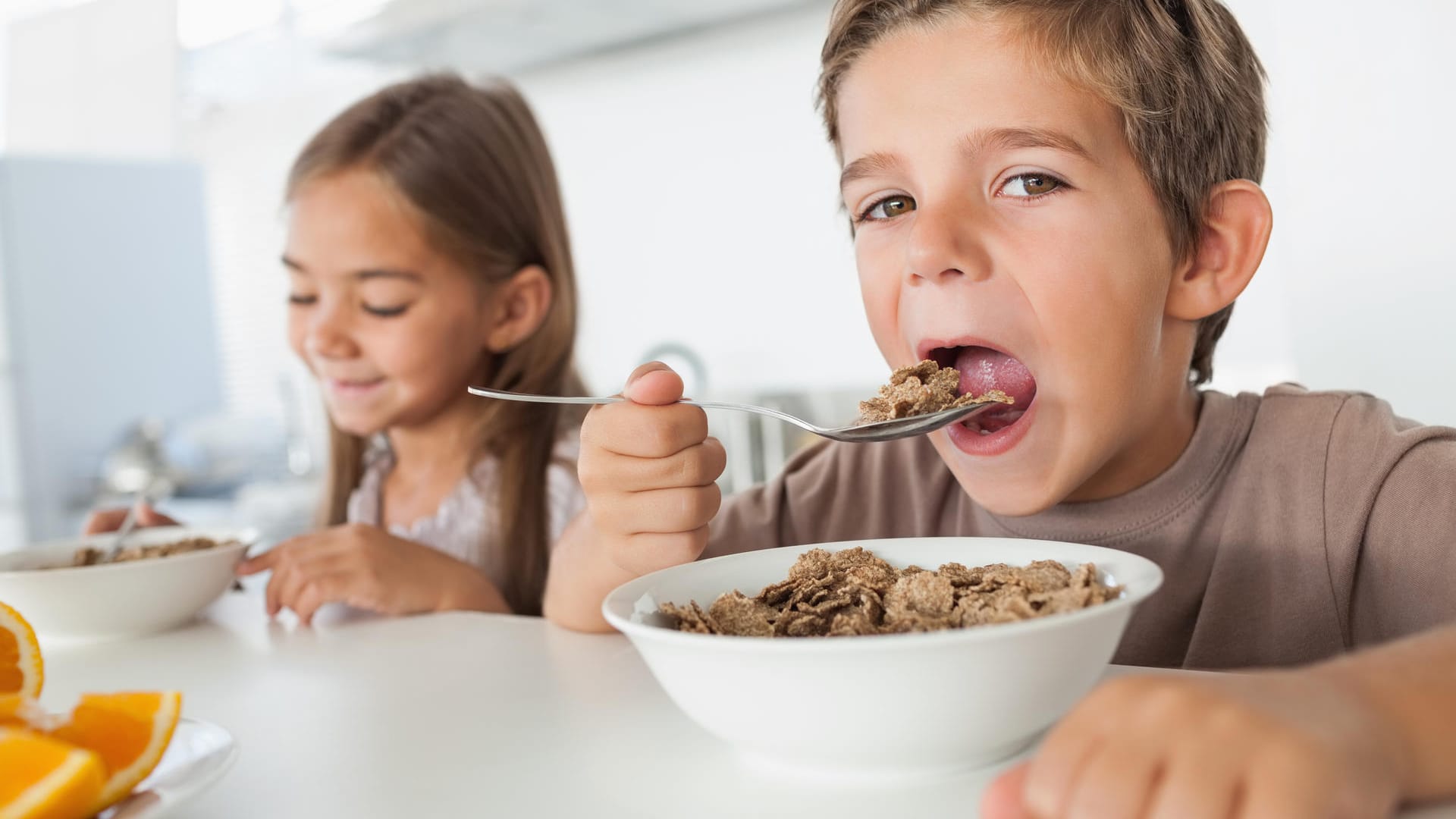 Ein Junge und ein Mädchen essen Cerialien