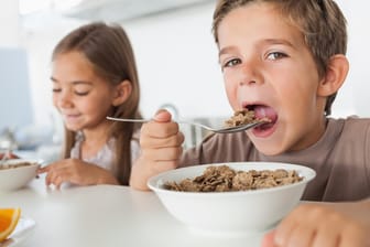 Ein Junge und ein Mädchen essen Cerialien