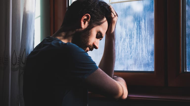 Mann am Fenster: Depressionen zeigen sich bei Männern anders als bei Frauen. (Symbolbild)