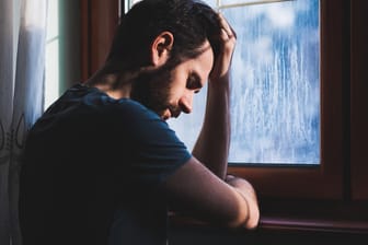 Mann am Fenster: Depressionen zeigen sich bei Männern anders als bei Frauen. (Symbolbild)