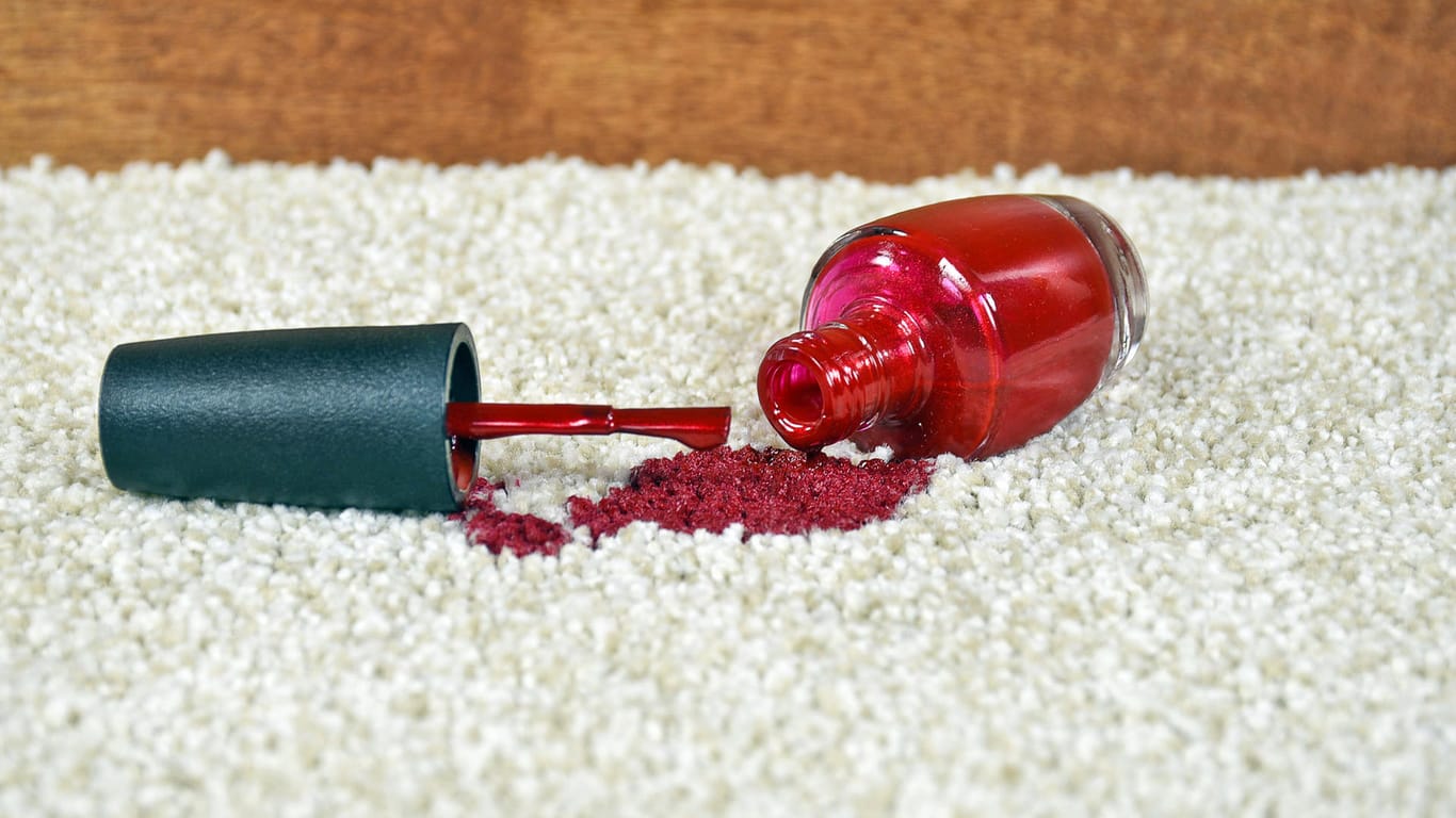 Ein ausgelaufener Nagellack auf dem Teppich