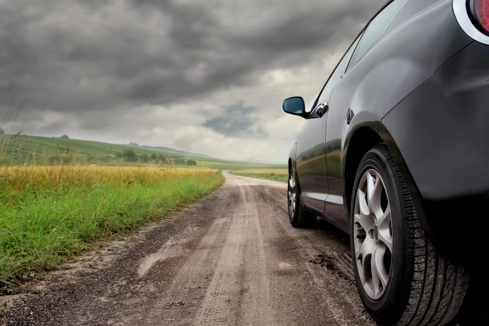 Auto auf Landweg: Starker Wind kann Ihr Auto ordentlich ins Schlingern bringen. Bei kräftigen Böen sollten Sie daher einige Tipps beherzigen.