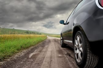Auto auf Landweg: Starker Wind kann Ihr Auto ordentlich ins Schlingern bringen. Bei kräftigen Böen sollten Sie daher einige Tipps beherzigen.