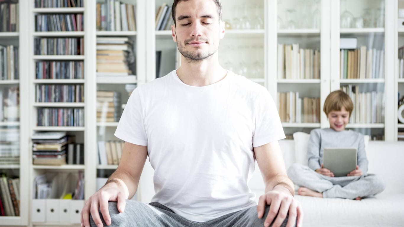 Ein Mann meditiert im Wohnzimmer: Meditation gehört zu den wirksamsten Achtsamkeitsübungen. Doch die Technik muss erlernt werden.