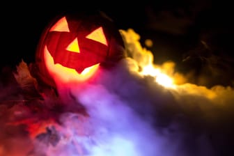 Ausgehöhlter Kürbis mit bunten Lichtern: Mit den richtigen Sprüchen wird Halloween noch gruseliger.