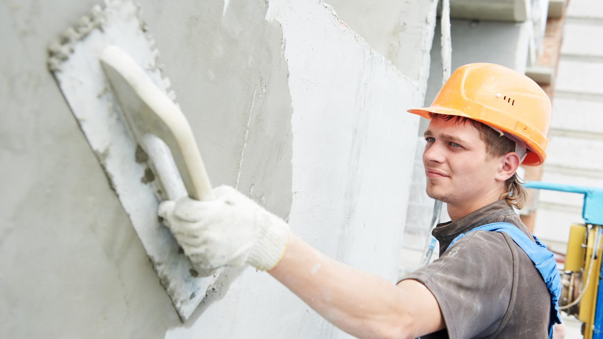 Construction workers plastering the facade of a building