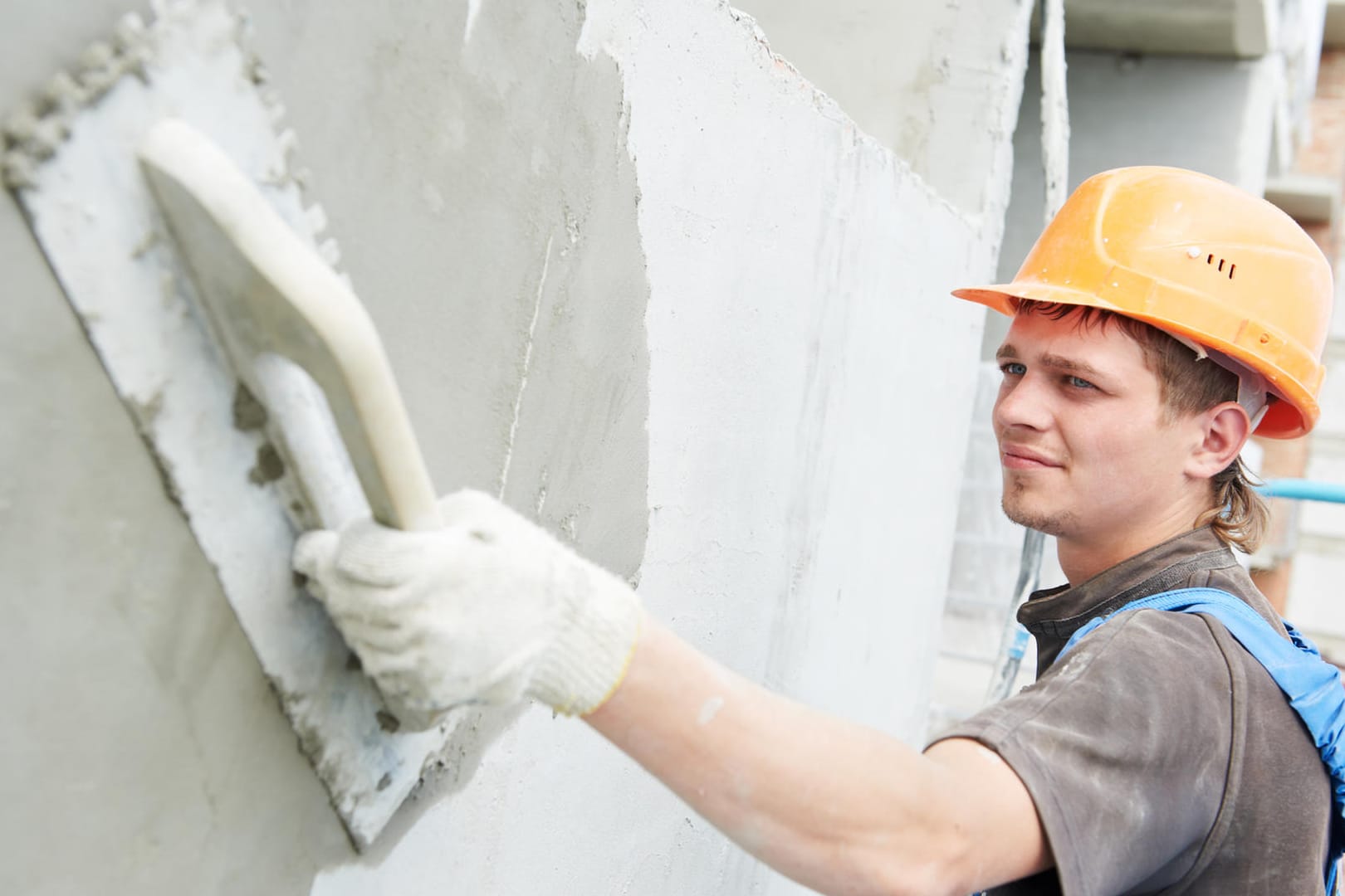 Construction workers plastering the facade of a building