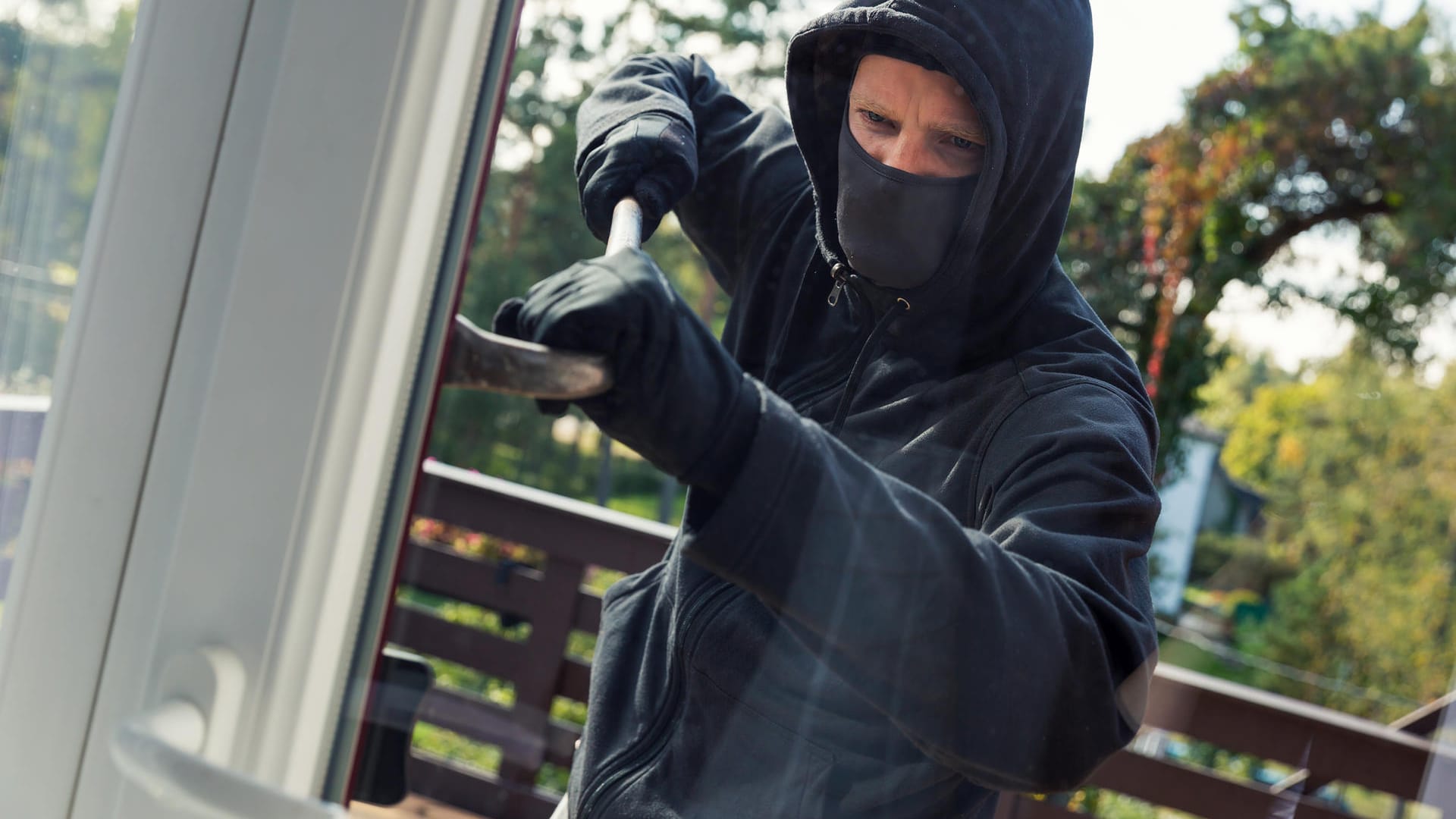 Einbrecher öffnet Fenster