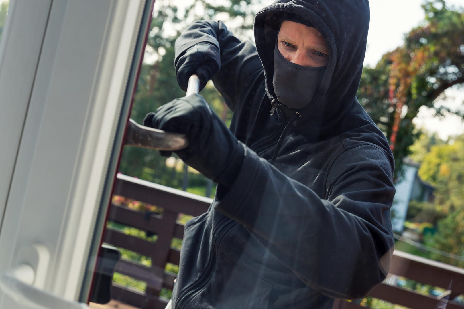 Einbrecher öffnet Fenster