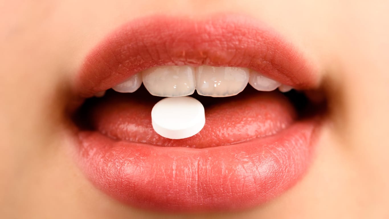 Mund nah mit weißer Tablette