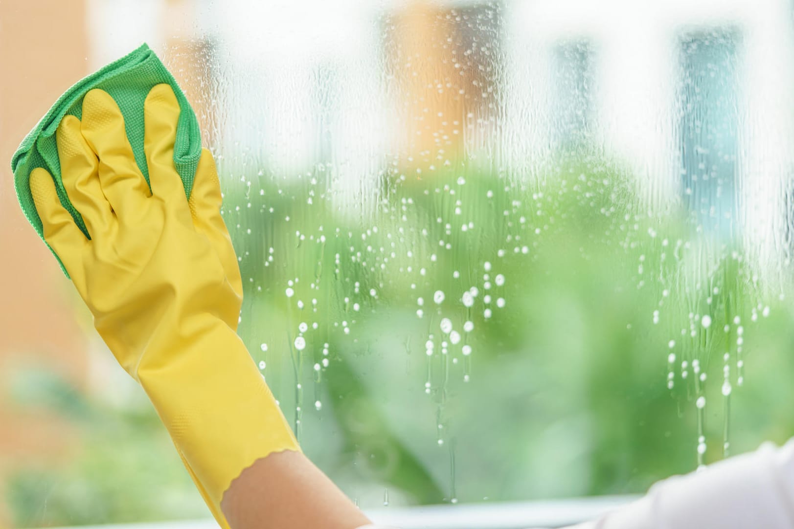 Ob Glasreiniger oder Spülmittel: Tragen Sie beim Fenster putzen Handschuhe, um Ihre Hände vor dem Austrocknen zu schützen.