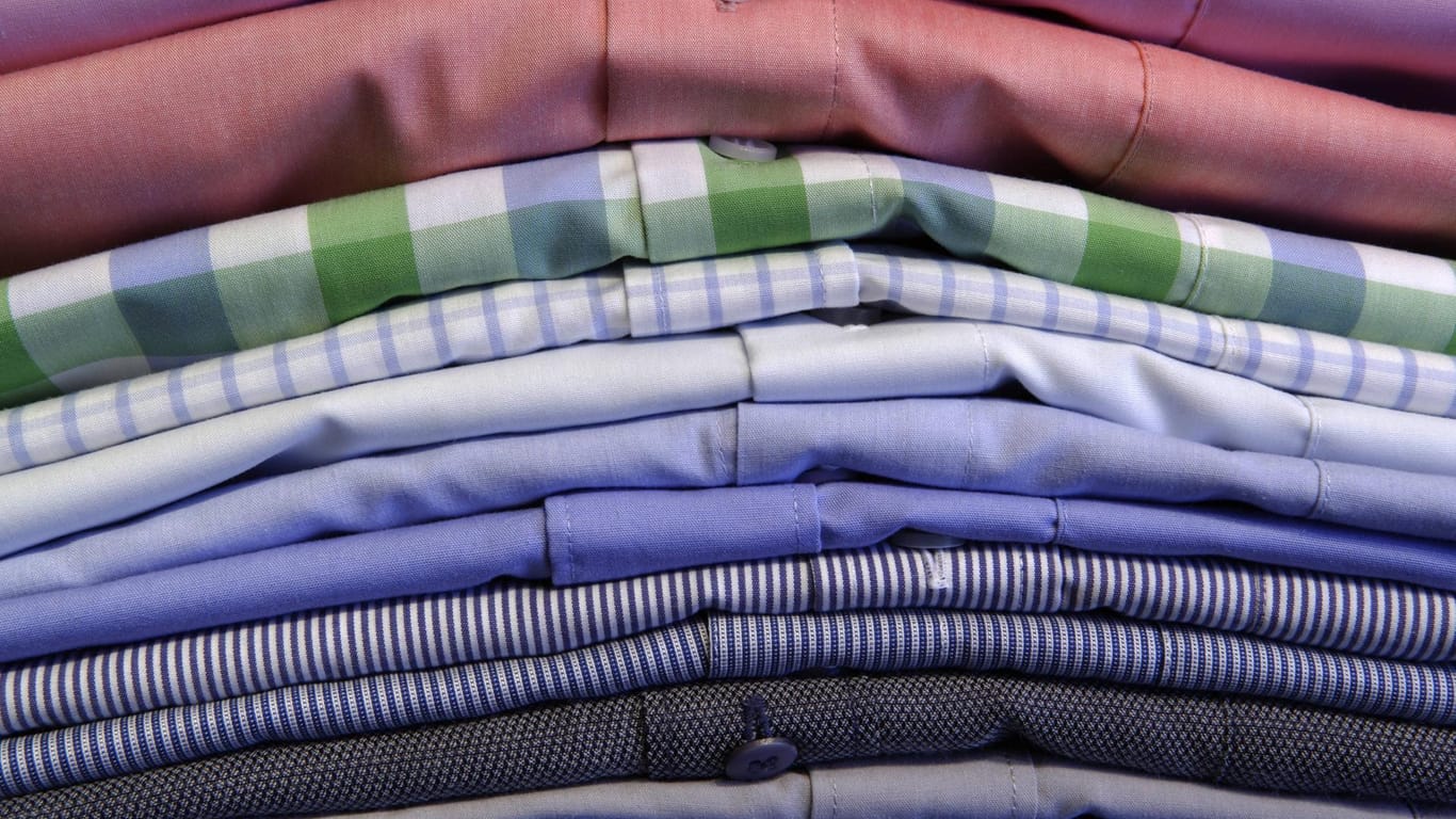 Hemdenstapel: Damit Ihre Hemden möglichst faltenfrei ankommen, sollten Sie Seidenpapier zwischenlegen.