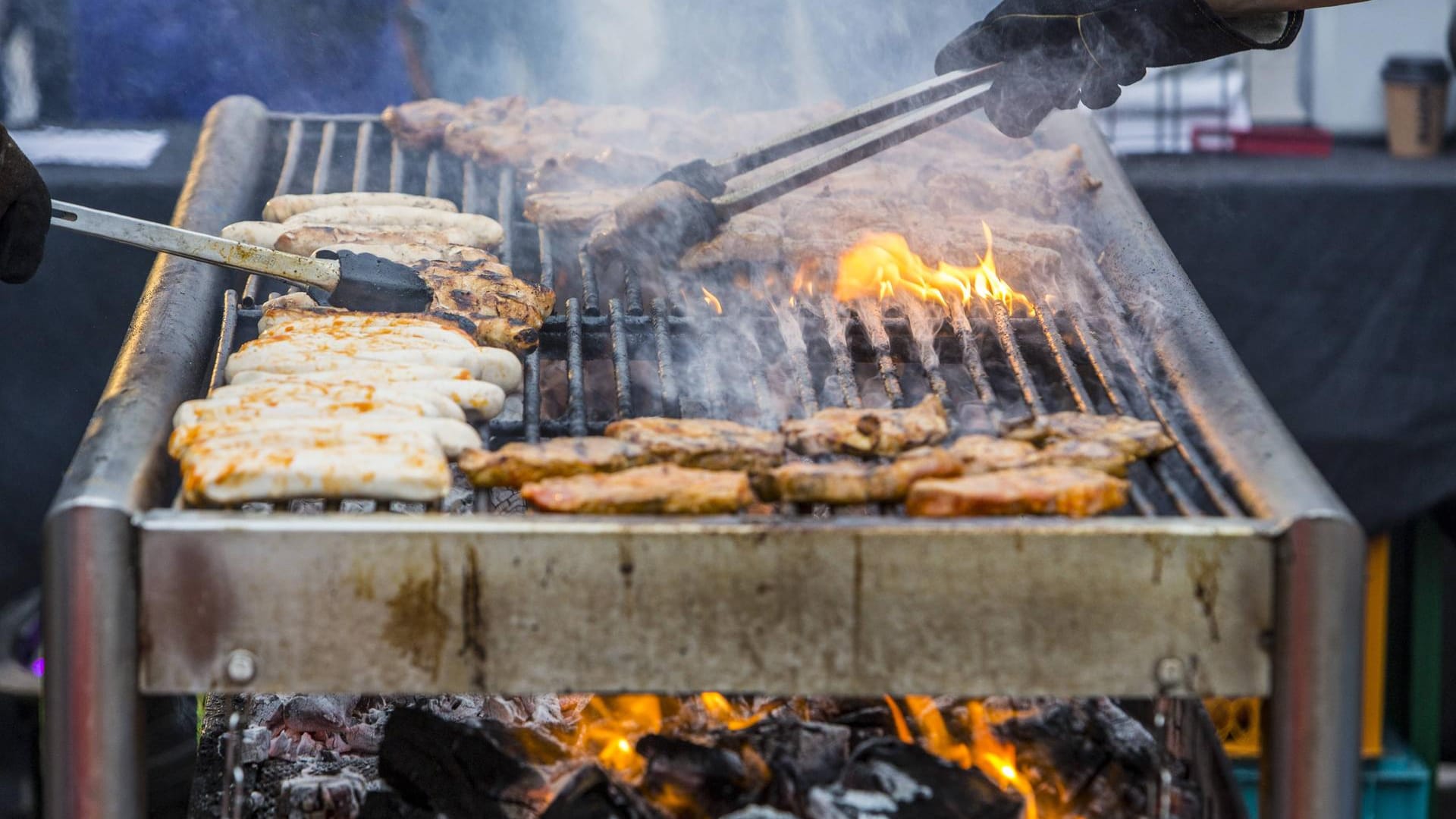 Grill Nackensteaks und Bratwürstchen werden auf einem Holzkohlengrill gegrillt