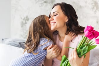 Kleines Mädchen umarmt Mutter