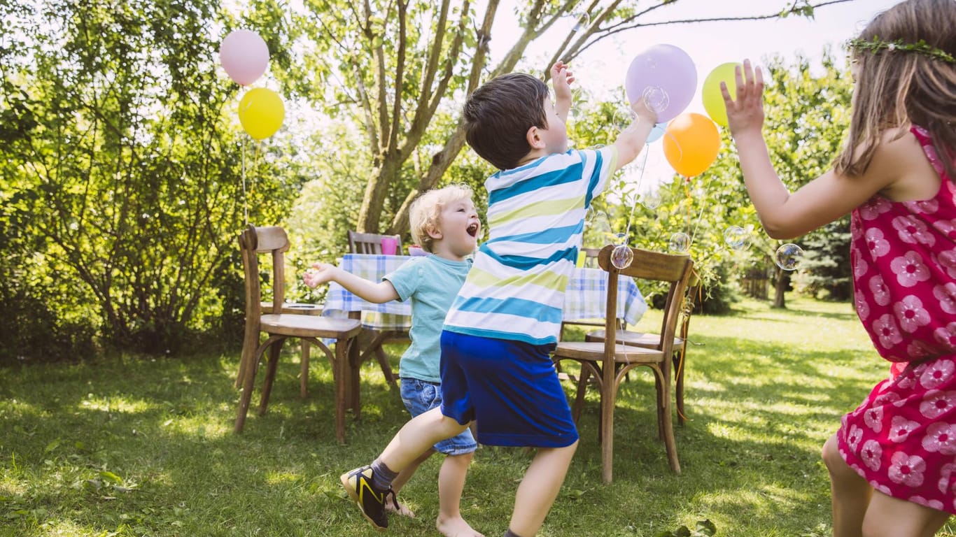 Spielende Kinder: Mit selbst aufgeblasenen Luftballons können die Kleinen im Garten toben.