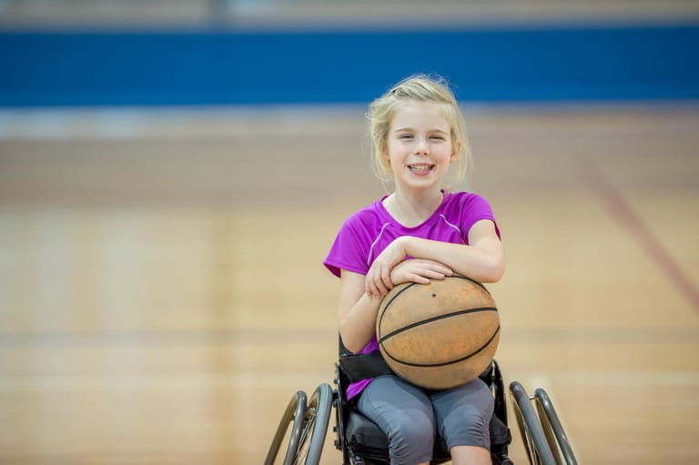 Kind im Rollstuhl mit Basketball