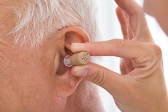 Hörgerät wird in ein Ohr gesteckt