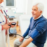 Mann zur Blutdruckmessung beim Arzt