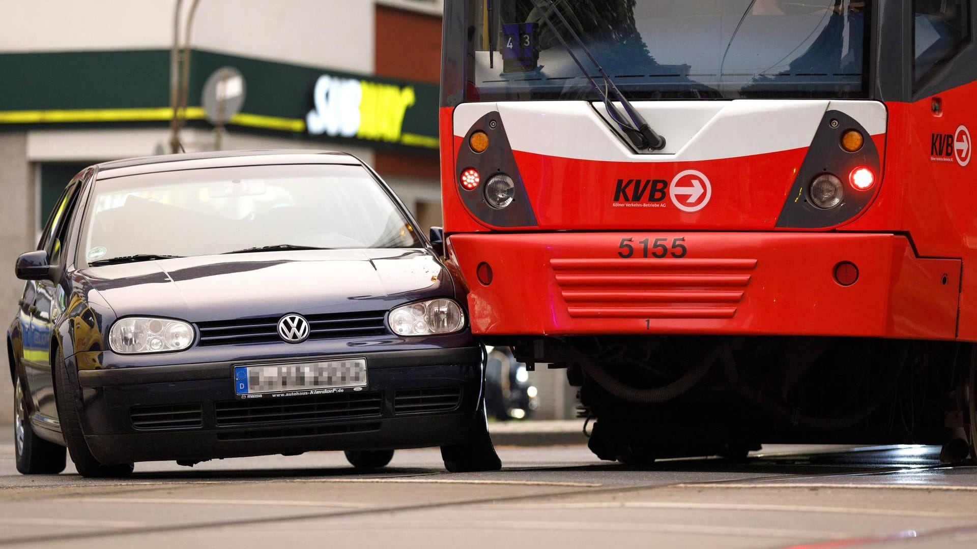 Ein Auto ist mit einer Bahn an einer Haltestelle in Köln zusammengestoßen