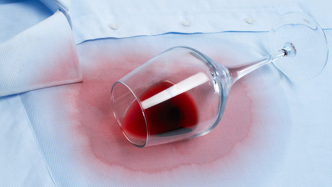 Rotweinfleck auf einem Hemd entfernen: Erst den Fleck sofort unter fließendem kaltem Wasser auswaschen und anschließend in die Waschmaschine.