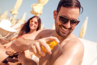 Pärchen am Strand cremt sich ein