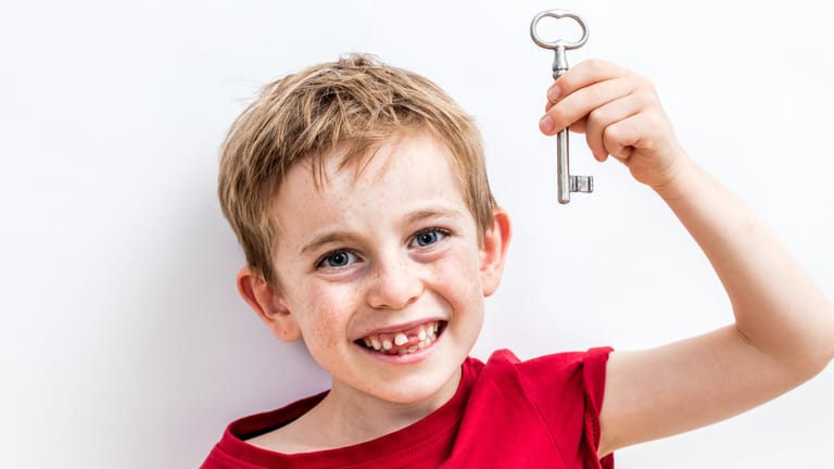 Junge mit Schlüssel: Erstklässler bekommen oft auch einen eigenen Wohnungsschlüssel. Ein Schlüsselanhänger verhindert, dass er verloren geht.
